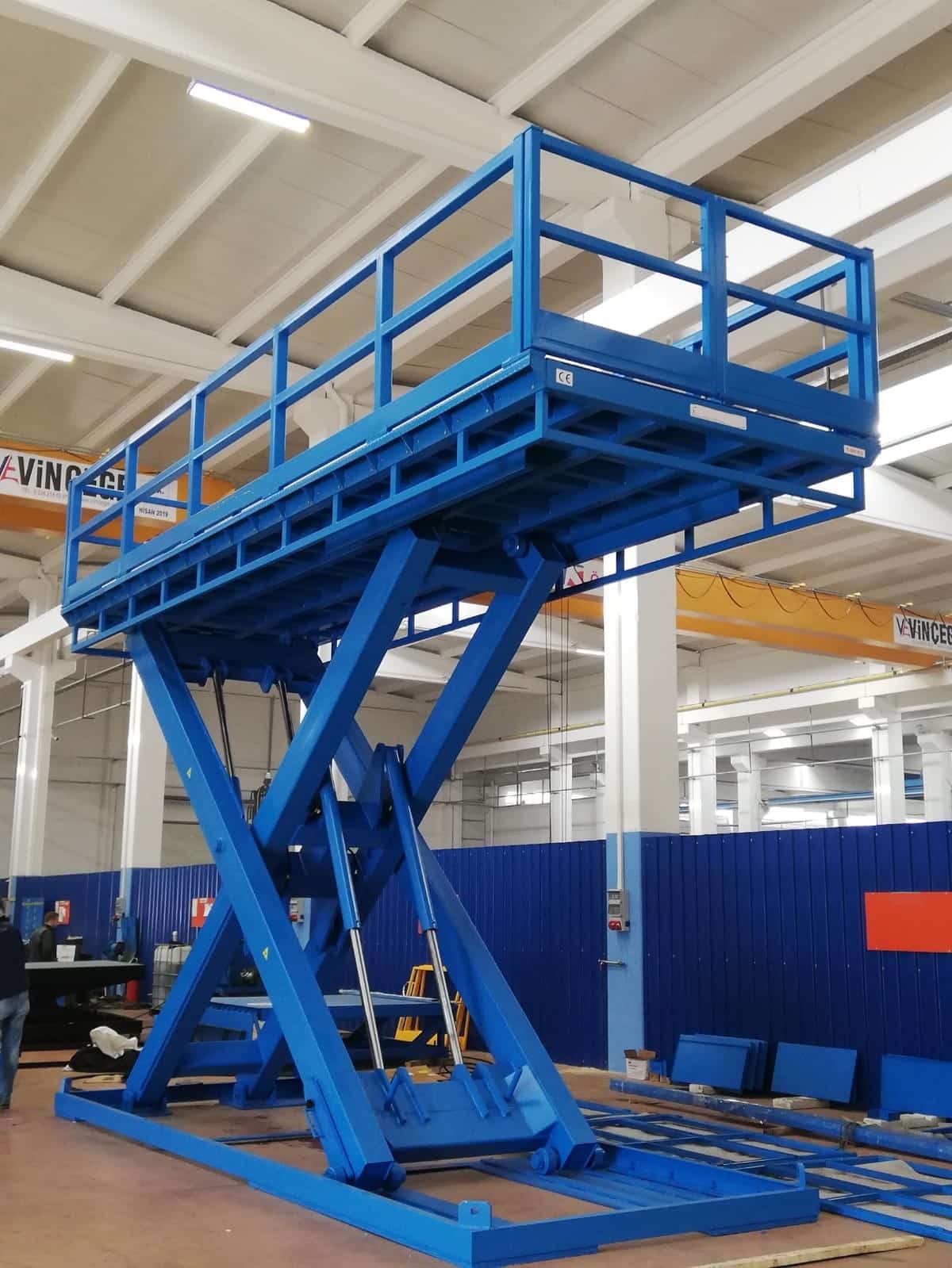 Blauer Scherenhubtisch in industrieller Fertigungsumgebung